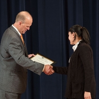 Doctor Potteiger shaking hands with an award recipient in a brown cardigan